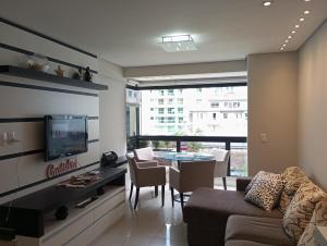 uma sala de estar com um sofá e uma mesa em Ótimo Apartamento vista mar a 70 metros em Itapema