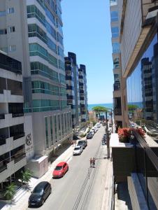 una calle de la ciudad con coches aparcados en la calle en Ótimo Apartamento vista mar a 70 metros en Itapema