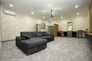 ein Wohnzimmer mit einem schwarzen Sofa und einem Tisch in der Unterkunft ART RESIDENCE Hotel in Taschkent