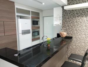a kitchen with a black counter top and a sink at Ótimo Apartamento vista mar a 70 metros in Itapema