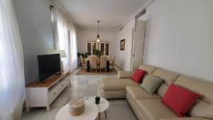a living room with a couch and a flat screen tv at Magdalena Plaza City Center 2 in Seville