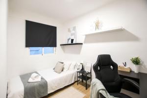 a living room with a couch and a chair at Apartamento moderno y céntrico en Huesca ciudad in Huesca