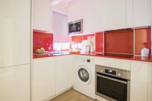 a kitchen with white cabinets and a washing machine at Apartamento moderno y céntrico en Huesca ciudad in Huesca +19 photos