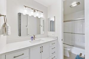 a white bathroom with a sink and mirror at Brooks Beach Vacations House B222 Oceanside in Oceanside