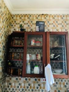 a kitchen cabinet with food items in it at One bedroom serviced apartment in Dar essalaam in Dar es Salaam
