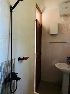 y baño con ducha y lavamanos. en One bedroom serviced apartment in Dar essalaam, en Dar es Salaam