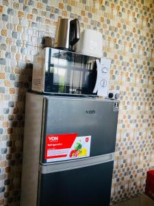 un forno a microonde seduto sopra un frigorifero di One bedroom serviced apartment in Dar essalaam a Dar es Salaam