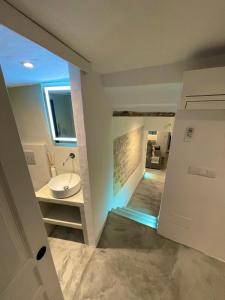 a bathroom with a sink and a hallway with a door at CASA MÚA in Frigiliana
