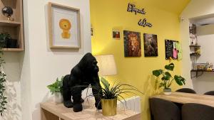 a black cat statue sitting on a table with plants at La Tropicale de Croix - Chambre d'Hôtes in Croix