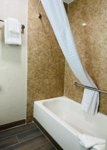 y baño con bañera y cortina de ducha. en Days Inn by Wyndham Ocala North, en Ocala