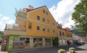 a yellow building on the side of a street at Appartement Alpenresort by Schladming-Appartements in Schladming