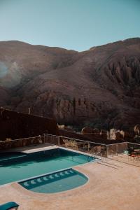 a swimming pool with a mountain in the background at Riad Rihana Dades in Boumalne