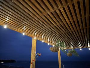 a wooden pergola with a view of the ocean at PUNTA VELEROS ROOFTOP in Los Órganos