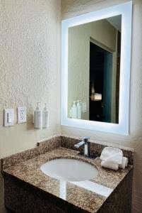y baño con lavabo y espejo. en Days Inn by Wyndham Ocala North, en Ocala