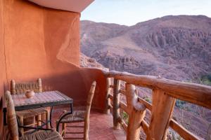 a table and chairs on a balcony with a view at Riad Rihana Dades in Boumalne