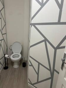 a bathroom with a toilet in a room at Logement Bienvenue in Lallaing