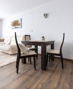 a dining room table with chairs and a couch at Large One Bedroom with Terrace next to the Ski Lift in Bansko