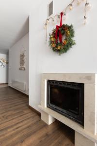 a living room with a fireplace and a christmas wreath at Large One Bedroom with Terrace next to the Ski Lift in Bansko