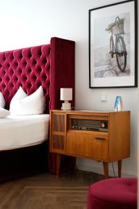 1 dormitorio con 1 cama y vestidor con cabecero rojo en Hotel Mühldorf en Mühldorf