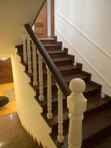 Un escalier en bois avec des balustrades blanches et du parquet dans l'établissement Madinty - Luxury villa with Amazing private garden مدينتي - فيلا فندقيه فاخرة, à Madinaty