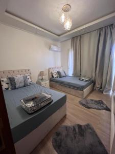 1 dormitorio con 2 camas y sofá en Madinty - Luxury villa with Amazing private garden مدينتي - فيلا فندقيه فاخرة en Madinaty