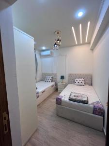 1 dormitorio con 2 camas en una habitación en Madinty - Luxury villa with Amazing private garden مدينتي - فيلا فندقيه فاخرة en Madinaty