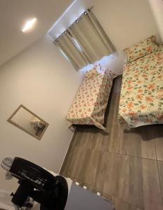 een kamer met 2 bedden en een haardroger. bij Residencial paraíso Pasárgada in Vera Cruz de Itaparica