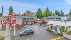 um carro estacionado num parque de estacionamento ao lado de um motel em Viking Motel em Portland