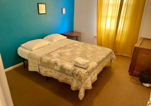 ein Schlafzimmer mit einem Bett und einer blauen Wand in der Unterkunft Artist in the Barn in Philadelphia