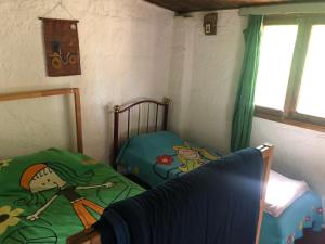 Habitación con 2 camas individuales y ventana. en Mi refugio, en La Paloma