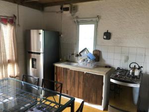 cocina con nevera de acero inoxidable y mesa en Mi refugio, en La Paloma