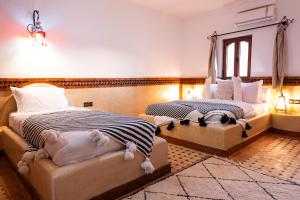 a bedroom with two beds and a window at Riad Rihana Dades in Boumalne
