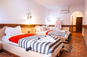 two beds in a hotel room with at Riad Rihana Dades in Boumalne