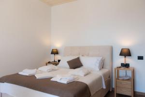 um quarto com uma cama com toalhas em White & black Suites em Platis Gialos, Sifnos