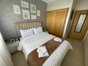 una camera da letto con un grande letto con asciugamani di Appartement avec piscine - Mohammadia a Mohammedia