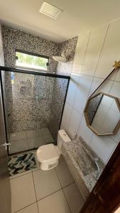 een badkamer met een douche, een toilet en een wastafel bij Residencial paraíso Pasárgada in Vera Cruz de Itaparica
