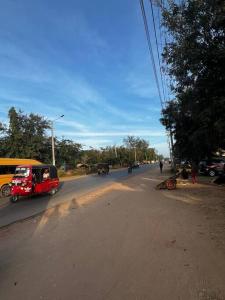 ein rotes Auto, das eine Straße entlang fährt. in der Unterkunft Private apartment in Diani in Ukunda