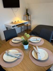 uma mesa de madeira com pratos e guardanapos em Ruhige, stadtnahe Wohnung im hamburger Westen em Schenefeld