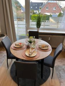 uma mesa de jantar com cadeiras e uma grande janela em Ruhige, stadtnahe Wohnung im hamburger Westen em Schenefeld