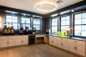 a large kitchen with windows and a counter with alcohol bottles at Palace Inn Blue Edgebrook in Houston