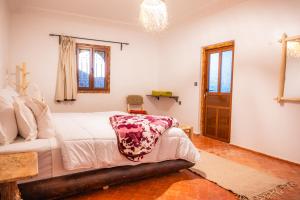 a bedroom with a bed and a chandelier at Riad Rihana Dades in Boumalne