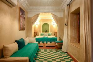 1 dormitorio con 2 camas y sofá en Riad Chez Henriette en Marrakech