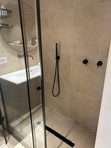 um chuveiro com uma porta de vidro na casa de banho em דירת נופש בהרצליה em Herzliyya B