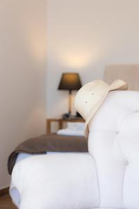 1 dormitorio con 2 camas y un sofá con sombrero en White & black Suites en Platís Yialós Sifnos