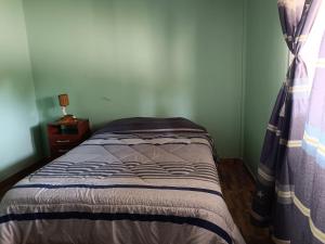 Dormitorio pequeño con cama con cortina en Cabaña El Apicultor en Cachí