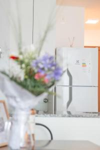 a vase filled with flowers in front of a refrigerator at Central y Moderno Apto 1 habitación - Lift Gaucho in Montevideo