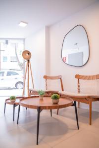 sala de estar con 2 sillas, mesa y espejo en Central y Moderno Apto 1 habitación - Lift Gaucho, en Montevideo