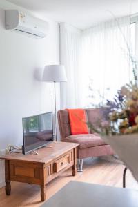 uma sala de estar com uma televisão e uma mesa de centro em Central y Moderno Apto 1 habitación - Lift Gaucho em Montevidéu