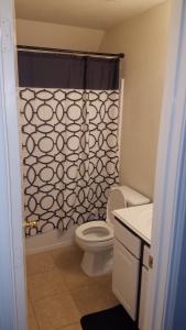 a bathroom with a toilet and a shower curtain at Large Modern Residence with private guest, family room & business office in Missouri City +12 photos