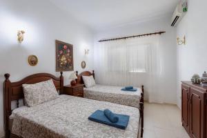 um quarto com 2 camas e toalhas em VILLA ROSADO - Moradia para 6 com AC, jardim a 5 min do centro de Albufeira em Albufeira